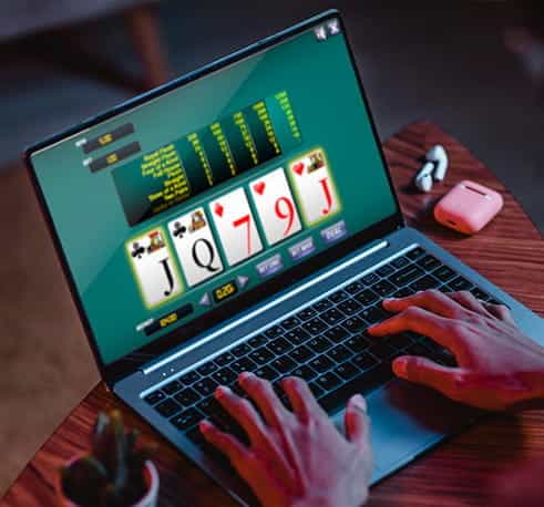 Jemand spielt Videopoker auf dem Laptop.