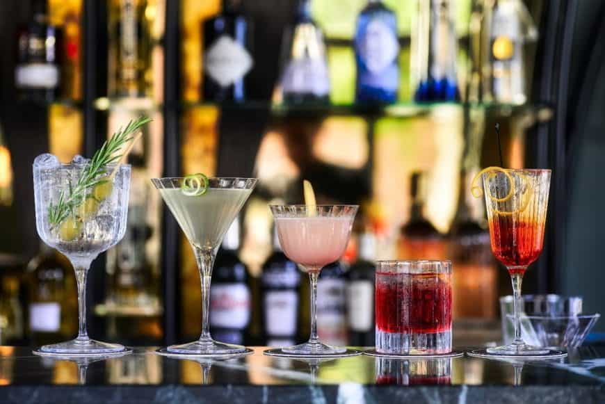 5 gefüllte Cocktailgläser in einer Casino Bar.