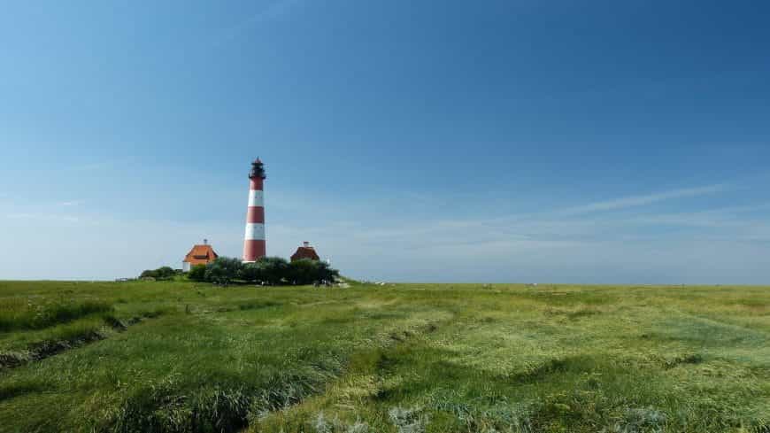 Zwei Häuser und ein Leuchtturm in Schleswig-Holstein.