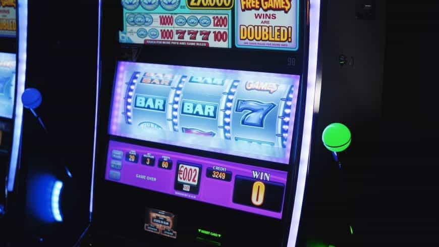 Bunt leuchtende Slot-Machine im Dunkeln mit insgesamt drei Walzen.