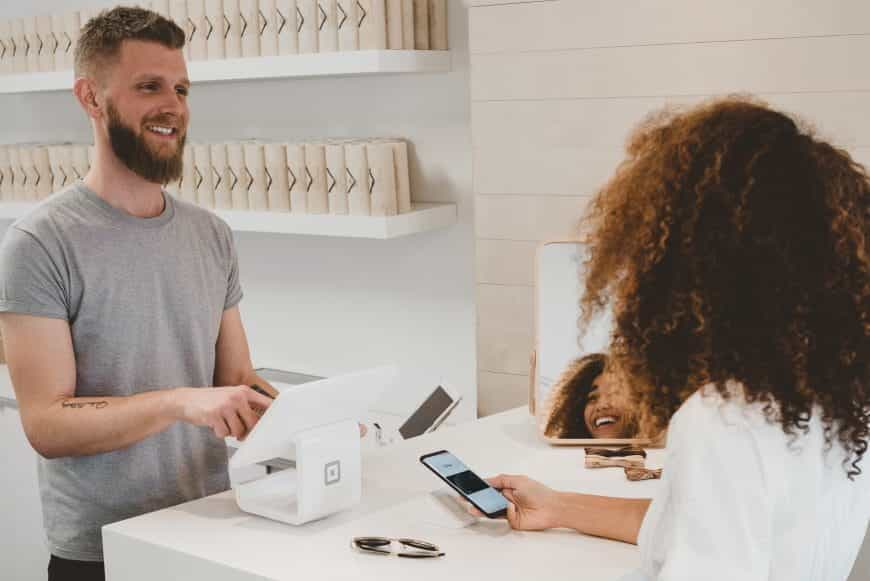 Frau bezahlt mit Apple Pay im Geschäft.