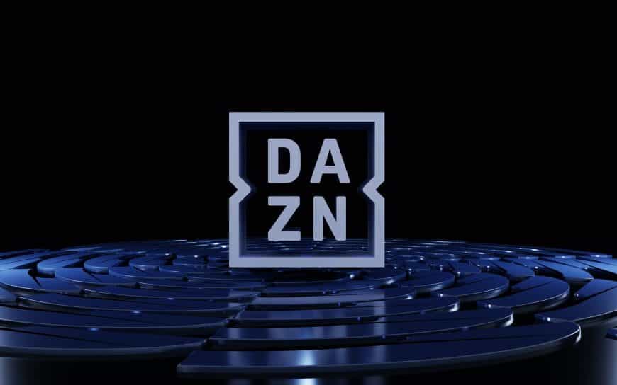 Das Logo des Sport-Streaming-Senders DAZN auf einem Podest vor dunklem Hintergrund.