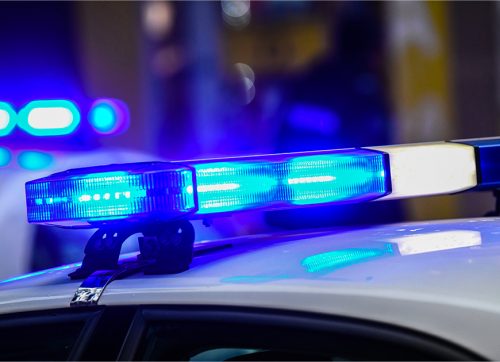 Blaulicht eines Polizeifahrzeugs bei einem nächtlichen Einsatz in einer Stadt.