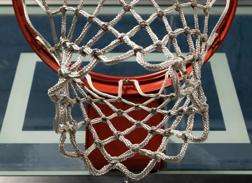 Ein Basketballkorb mit einem weißen Netz, von oben durch den Ring hindurch fotografiert.