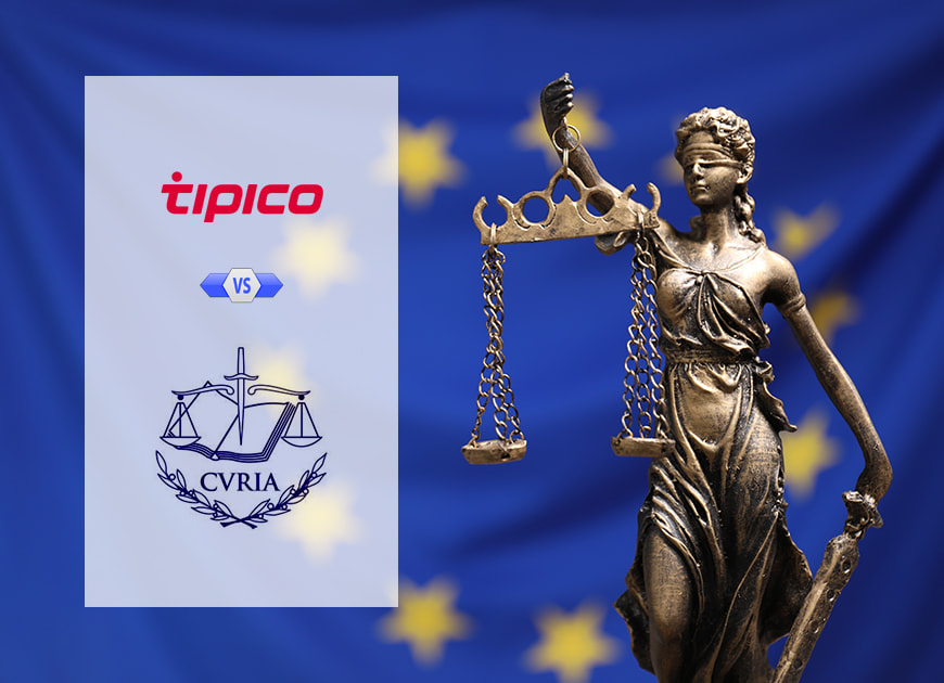 Eine Justitia-Statue hält mit erhobener Hand eine Waage und steht vor einem tiefblauen Himmel.